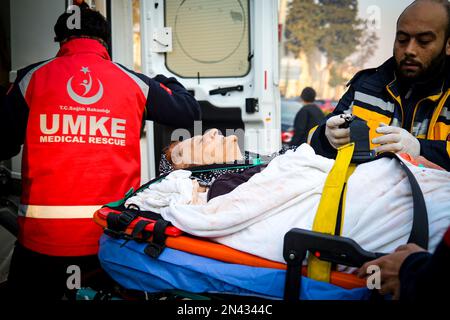 Hatay, Turchia. 08th Feb, 2023. Una donna di 65 anni che è stata tolta dalle macerie viene portata in ambulanza. La gente chiede più aiuto nel distretto di Antakya di Hatay, una delle città dove i detriti più grandi sono stati sperimentati. La Turchia ha vissuto il più grande terremoto di questo secolo nella regione di confine con la Siria. Il terremoto è stato misurato a 7,7 magnitudine. (Foto di Murat Kocabas/SOPA Images/Sipa USA) Credit: Sipa USA/Alamy Live News Foto Stock