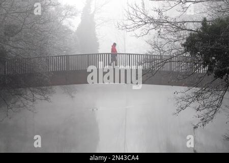 Chippenham, Wiltshire, Regno Unito. 8 febbraio 2023. Poiché il freddo inverno nebbioso colpisce molte parti del Regno Unito, un uomo è ritratto a camminare attraverso un ponte sul fiume Avon a Chippenham, Wiltshire. Crediti: Lynchpics/Alamy Live News Foto Stock