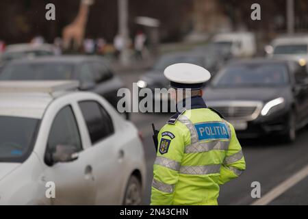 Bucarest, Romania - 8 febbraio 2023: Ufficiale di polizia stradale rumeno nel centro di Bucarest durante l'ora di punta. Foto Stock