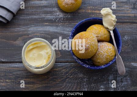 Panini di cardamomo di zucca freschi fatti in casa senza lievito con panna cosparsa di zucchero a velo su asse di legno, stile rustico, piatto Foto Stock