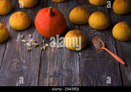 Panini di zucca freschi fatti in casa senza lievito con cardamomo su sfondo di legno, stile rustico, spazio Foto Stock