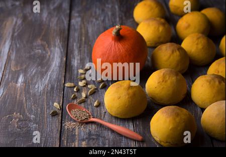 Panini di zucca freschi fatti in casa senza lievito con cardamomo su sfondo di legno, stile rustico, spazio Foto Stock