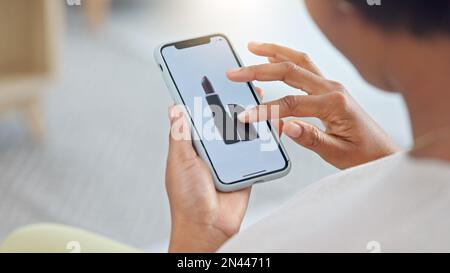 Shopping online e scorrimento attraverso i prodotti per il trucco per trovare una vendita o uno sconto. Mani di una donna che naviga cosmetici sul suo telefono dall'alto Foto Stock