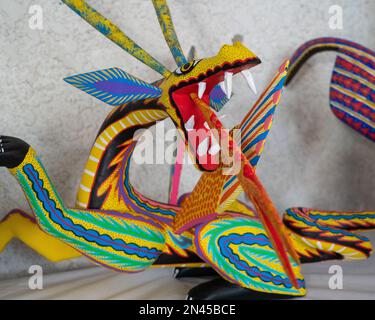 Un drago alebrije che respira il fuoco in un negozio/laboratorio artigianale a San Antonio Arrazola, Oaxaca, Messico. Alebrijes sono creature colorate dipinte re Foto Stock