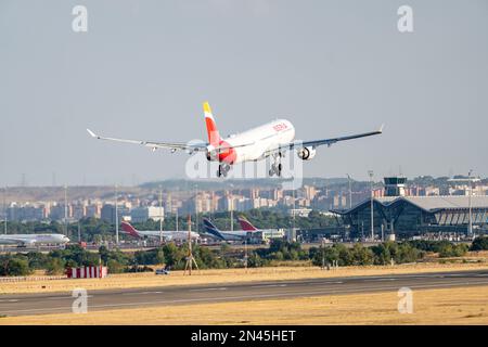 Iberia airbus bianco, rosso e giallo A330-302 A333 con numero di immatricolazione EC-MAA e carrello abbassato per l'atterraggio all'aeroporto di Barajas, Madrid. Foto Stock