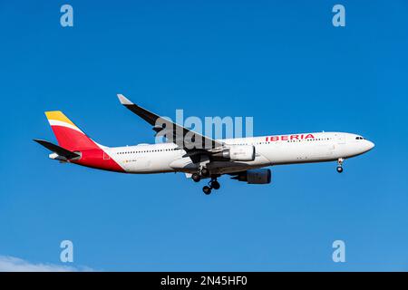 Iberia airbus bianco, rosso e giallo A330-302 A333 con numero di immatricolazione EC-MAA e carrello abbassato per l'atterraggio all'aeroporto di Barajas, Madrid. Foto Stock