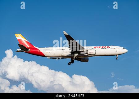 Iberia airbus bianco, rosso e giallo A330-302 A333 con numero di immatricolazione EC-MAA e carrello abbassato per l'atterraggio all'aeroporto di Barajas, Madrid. Foto Stock