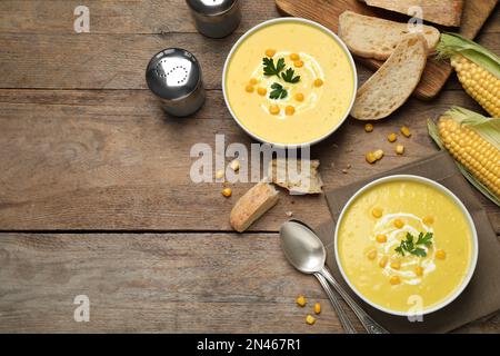 Deliziosa zuppa di mais cremosa servita su un tavolo di legno, piatto. Spazio per il testo Foto Stock
