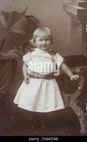 Vecchia foto scattata in Germania intorno al 1900. Una giovane ragazza dai capelli biondi con vestito bianco è in posa Foto Stock