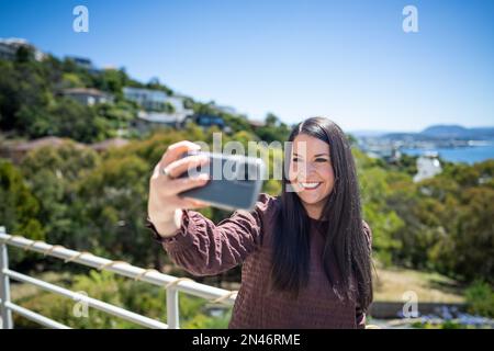 Ragazza che prende un selfie in vacanza in australia. Donna d'affari scattare una foto del telefono di se stessa in un viaggio im australia Foto Stock