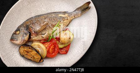 Pesce dorado fritto, in un piatto, con verdure alla griglia Foto Stock