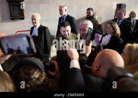 Il presidente ucraino Volodymyr Zelensky scuote le mani con i parlamentari mentre cammina con il presidente della Camera dei Comuni, Sir Lindsay Hoyle, e il presidente della Camera dei Lord McFall, attraverso il palazzo di Westminster, Londra. Data immagine: Mercoledì 8 febbraio 2023. Foto Stock