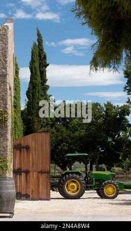 Robertson, Sud Africa del Capo Occidentale. 2023. Trattore verde con ruote gialle e rimorchio parcheggiato a metà strada in un granaio. Foto Stock