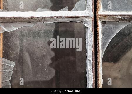 Vetri della finestra rotti con una faccia urlante simile a quella di un essere umano Foto Stock