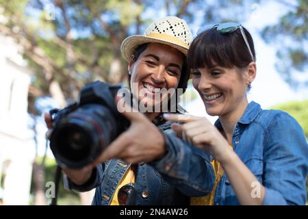 amici donne che usano una reflex digitale durante le vacanze Foto Stock