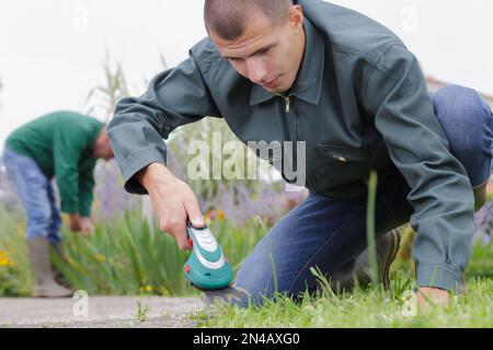 uomo adulto che innaffia la segheria nel cortile posteriore Foto Stock