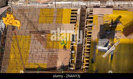 Vista dall'alto di piastre di fondazione in cemento e acciaio in un cantiere di un edificio di uffici. Foto Stock