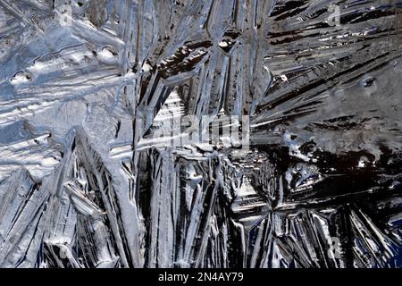 Schegge di ghiaccio acqua ghiacciata forma modelli guardare nero vista dall'alto fotografato in un contenitore scuro opaco in un freddo giorno UK KATHY DEWITT Foto Stock