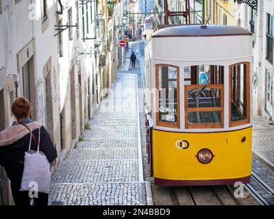 Vista frontale del trolly giallo con adesivo WI-Fi su una ripida collina a Lisbona, Portogallo Foto Stock