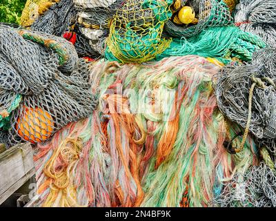 Le reti da pesca realizzate con fili colorati rossi, verdi e gialli sono impilate per essere immagazzinati al Fisherman's Terminal nella zona Ballard di Seattle. Foto Stock