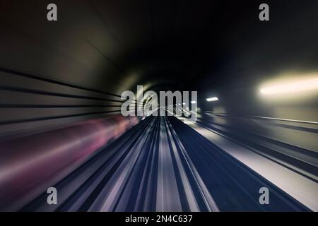 Binario ferroviario nel tunnel sotterraneo in movimento sfocato. Punto di vista dal treno. Foto Stock