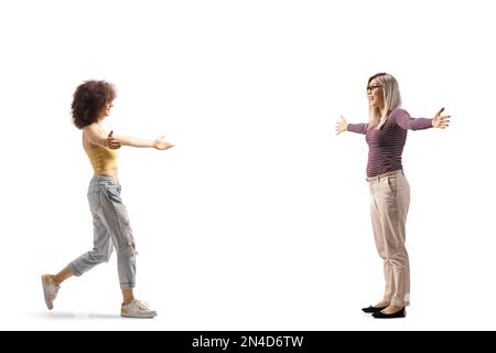 Immagine a tutto profilo di due giovani donne che si incontrano e si salutano isolate su sfondo bianco Foto Stock