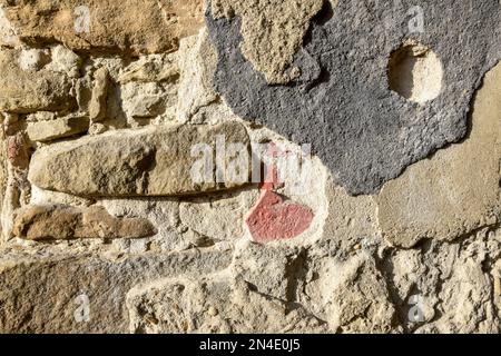 Struttura di vecchio muro di pietra con intonaco collassato. Sfondo della superficie dell'edificio in shabby. Distrutto muro di pietra con intonaco caduto. Superficie intatta. Foto Stock