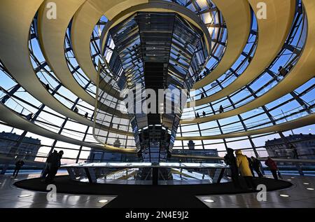 Berlino, Germania. 08th Feb, 2023. La gente cammina attraverso la cupola dell'edificio del Reichstag mentre il sole tramonta. Credit: Philipp Znidar/dpa/Alamy Live News Foto Stock