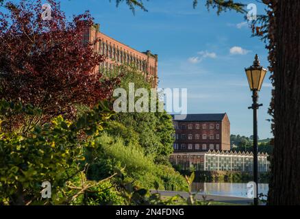 East Mill, e il più piccolo North Mill, storici mulini di filatura del cotone a Belper, Derbyshire, Inghilterra, visto dai Belper River Gardens Foto Stock