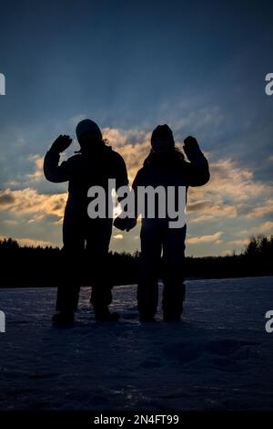 Bambini contro il tramonto, vacanze invernali in Austria Foto Stock