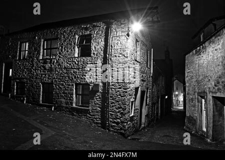 Street scene in Settle, una città mercato nel Yorkshire Dales, visto di notte sotto l'illuminazione stradale vicino a Bowskills Yard. Foto Stock