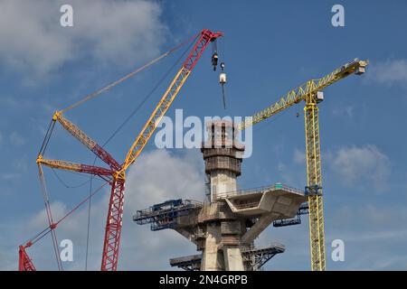 Gru che trasportano cemento alla torre principale del ponte, costruendo il ponte del porto di New Corpus Christi, Corpus Christi, Texas. Foto Stock