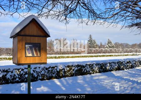 Scatola di nidificazione in legno trasformata in biblioteca pubblica gratuita. Prenota una scatola nel paesaggio innevato del parco del castello. Inverno al castello di Holesov. Foto Stock