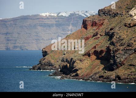 Una vista dal villaggio di Manolas sulla Thirasia che guarda attraverso la caldera a Santorini con una vista di Imerovigli Foto Stock