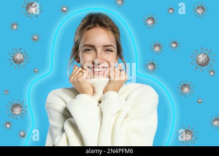 Immunità più forte - migliore resistenza alle malattie. Giovane donna che indossa un maglione caldo circondato da virus su sfondo chiaro Foto Stock