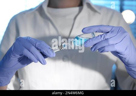 Donna siringa di riempimento con vaccino dal flaconcino, primo piano Foto Stock