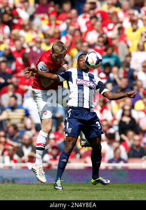 Arsenal's Per Mertesacker, left, competes for the ball with West Bromwich Albion's Saido Berahino during their English Premier League soccer match at Emirates Stadium in London, Sunday, May 4, 2014. (AP Photo/Sang Tan)