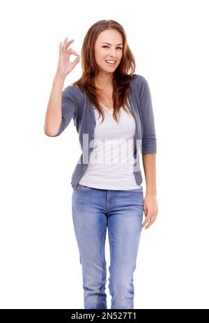 Va bene. Donna vestita casualmente che dà il segno ok mentre isolato su bianco. Foto Stock