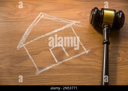 Giudica l'asta e il concetto del bene immobile con il disegno della casa e del gavel su fondo di legno. Foto Stock