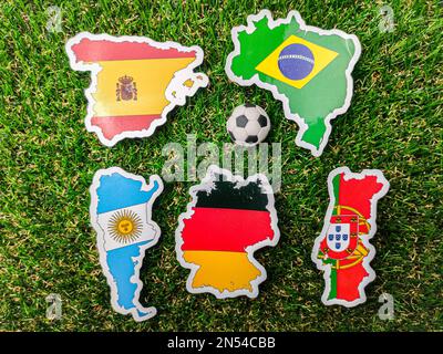 Una palla e Portogallo, tedesco, Spagna, Argentina e brasile adesivo bandiera è su un campo verde. Foto Stock