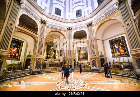 Persone che guardano la pittura di Caravaggio, le sette opere di Misericordia, nella cappella. Al Pio Monte della Misericordia di Napoli, Napoli, Italia Foto Stock