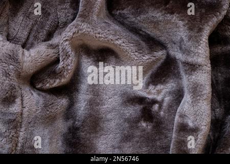 Sfondo di un camice di pelle di pecora nero da uomo in pelliccia sintetica, primo piano di fondo in pelliccia Foto Stock