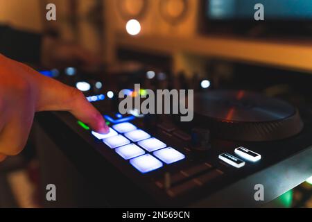 Primo piano delle mani dell'uomo che fanno musica battute e suoni con una batteria pad neon macchina leggera. Foto di alta qualità Foto Stock