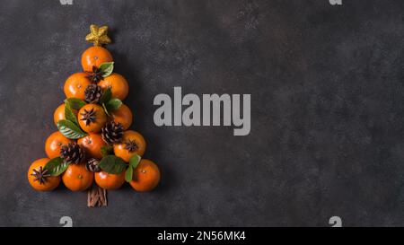 vista dall'alto della forma dell'albero di natale fatta di tangerini e coni di pino con spazio copia. Risoluzione e foto di alta qualità Foto Stock