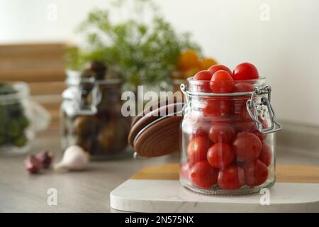 Vasetto di decapaggio con pomodori freschi sul banco in cucina. Spazio per il testo Foto Stock