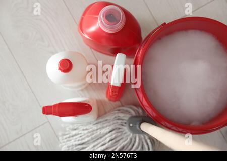 Secchio, spazzolone e diversi prodotti per la pulizia su pavimenti interni, piano Foto Stock