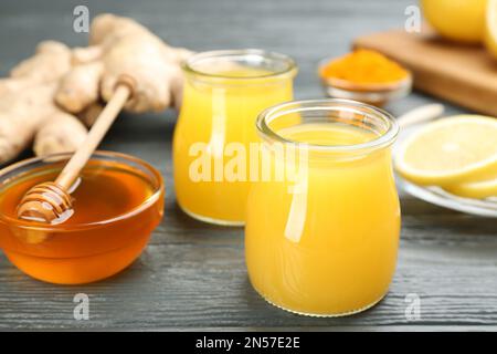 Immunità aumentare la bevanda e gli ingredienti su tavolo di legno grigio, primo piano Foto Stock