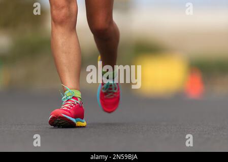 Scarpe da corsa, i piedi e le gambe close up runner jogging in azione e motion Foto Stock