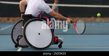 Gli uomini in sedia a rotelle giocano a tennis sul campo da tennis Foto Stock