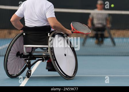 Gli uomini in sedia a rotelle giocano a tennis sul campo da tennis Foto Stock